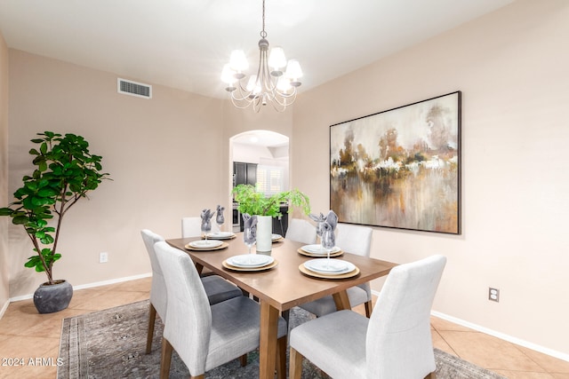 tiled dining space featuring a chandelier