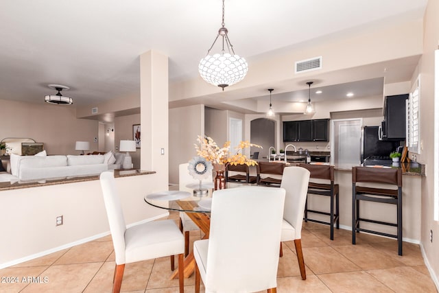 dining area featuring a chandelier and light tile patterned flooring