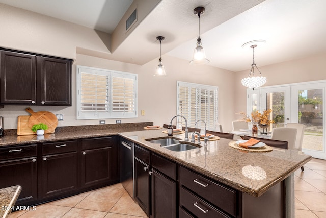 kitchen with light stone counters, hanging light fixtures, sink, stainless steel dishwasher, and light tile patterned flooring