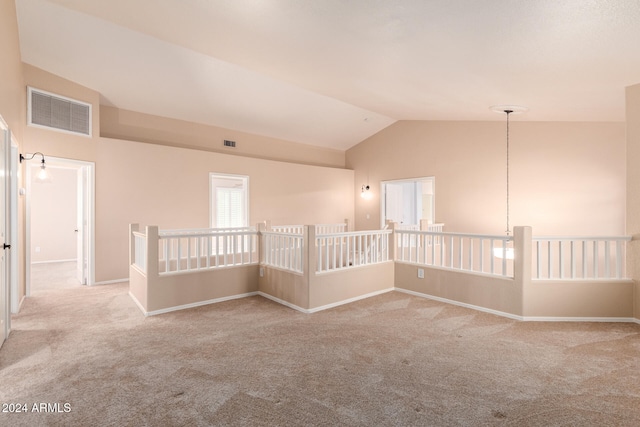 empty room with vaulted ceiling and light carpet