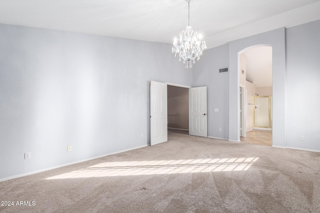 carpeted spare room with a chandelier