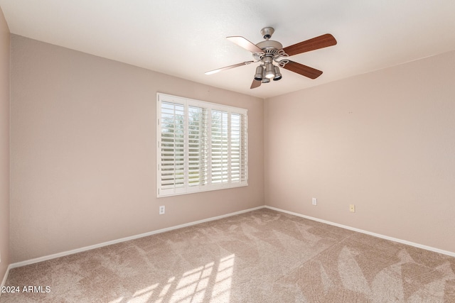 carpeted spare room with ceiling fan