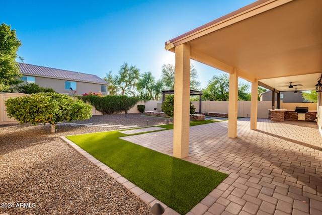 view of yard with ceiling fan and a patio