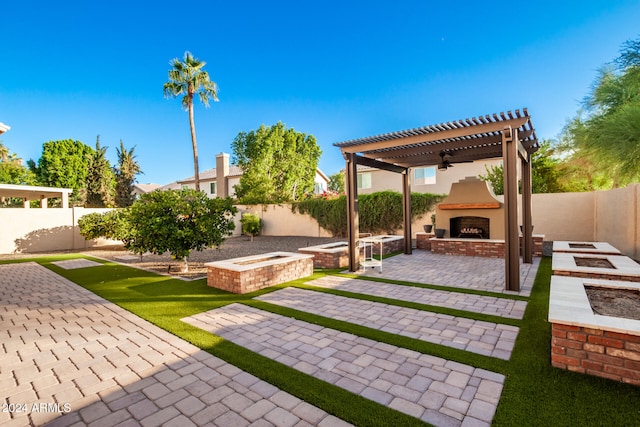 view of yard with a patio area, an outdoor fire pit, exterior fireplace, and a gazebo