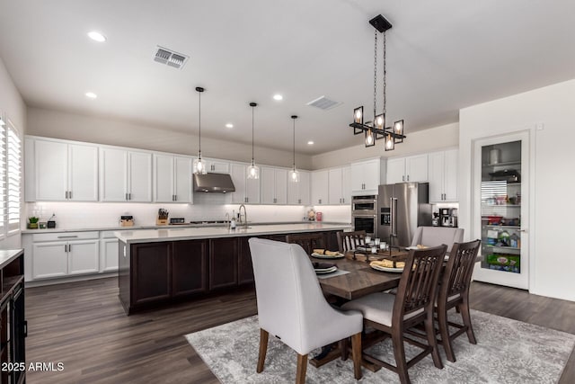 dining space with a chandelier, dark wood-style flooring, and recessed lighting
