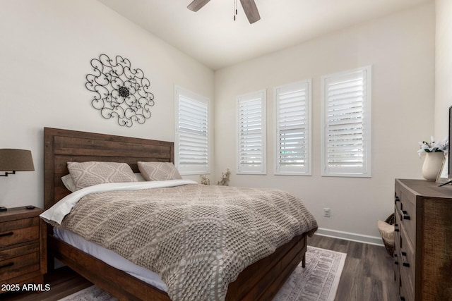 bedroom featuring dark wood finished floors, baseboards, multiple windows, and ceiling fan