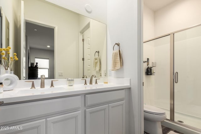 full bath with a shower stall, toilet, and double vanity