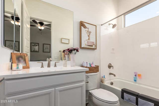 bathroom with vanity, washtub / shower combination, toilet, and ceiling fan