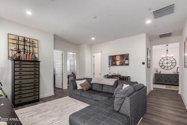 living room featuring dark wood-style floors, baseboards, recessed lighting, and a chandelier