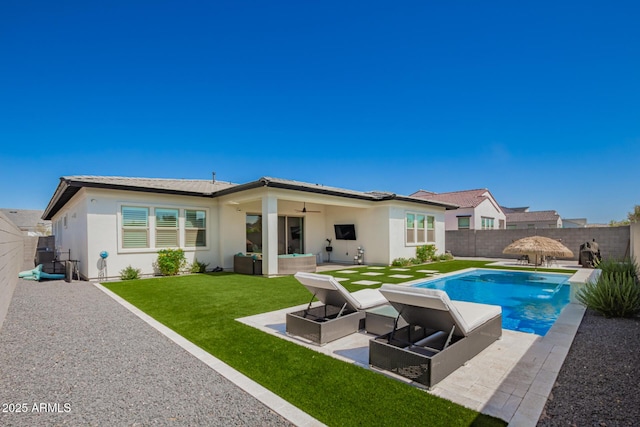 back of property with a ceiling fan, a patio area, stucco siding, and an outdoor hangout area