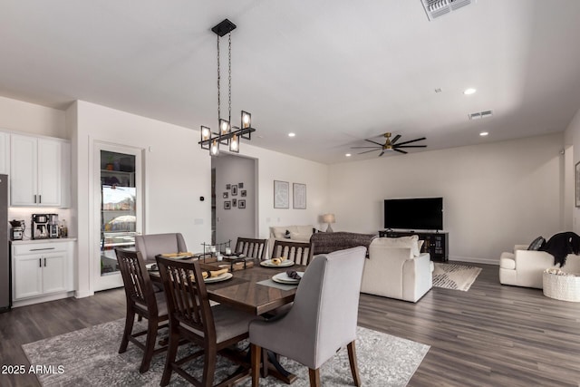 dining area featuring dark wood-style floors, recessed lighting, a ceiling fan, a chandelier, and baseboards