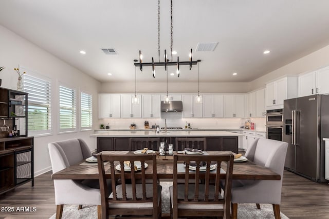 dining room featuring dark wood-style floors, recessed lighting, and baseboards
