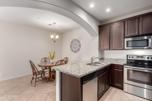 kitchen featuring visible vents, a sink, dark brown cabinetry, appliances with stainless steel finishes, and light tile patterned floors