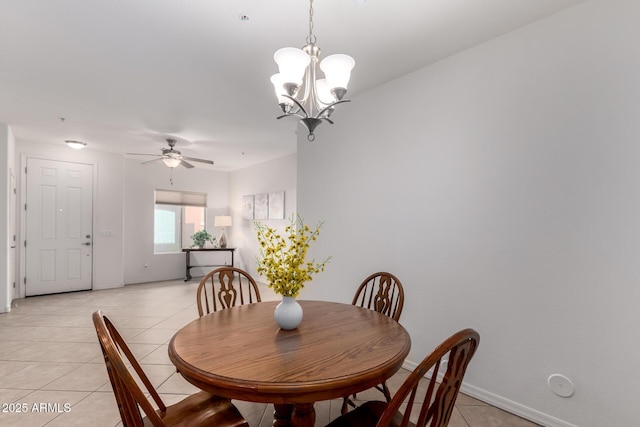 dining room featuring light tile patterned floors, ceiling fan with notable chandelier, and baseboards