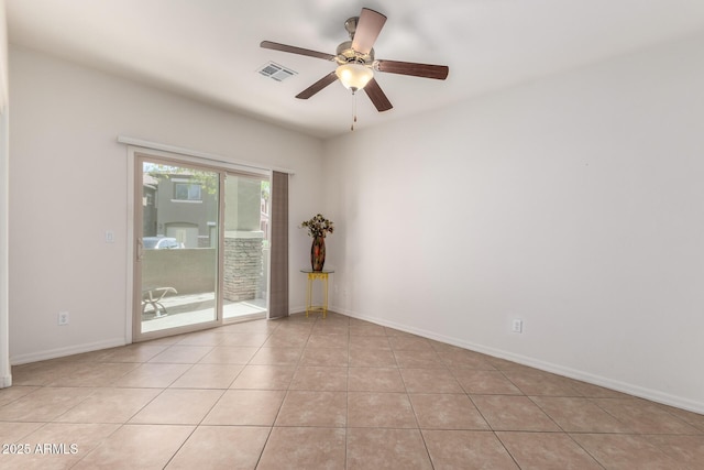 spare room with light tile patterned floors, visible vents, ceiling fan, and baseboards