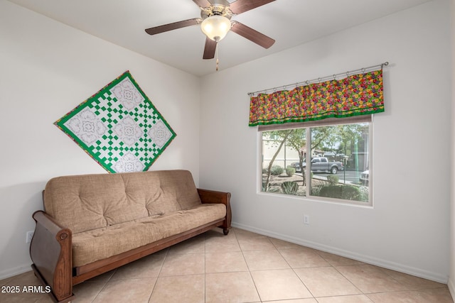 sitting room featuring light tile patterned floors, a ceiling fan, and baseboards