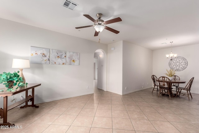 dining room featuring light tile patterned floors, visible vents, baseboards, arched walkways, and ceiling fan with notable chandelier