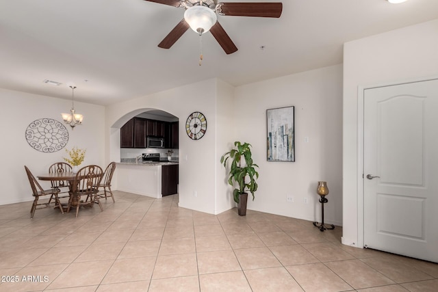 dining space featuring light tile patterned floors, visible vents, and ceiling fan with notable chandelier