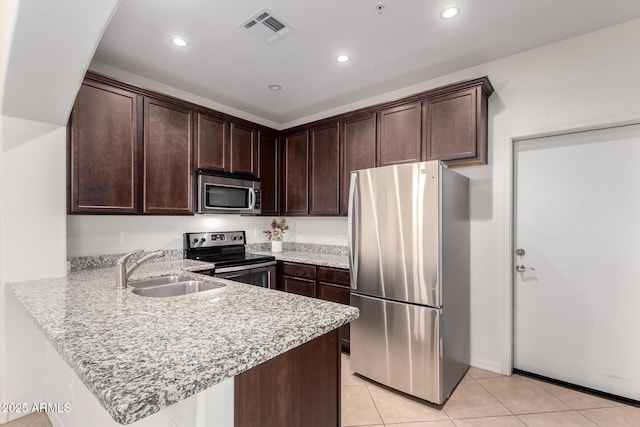 kitchen with visible vents, a sink, dark brown cabinetry, appliances with stainless steel finishes, and a peninsula