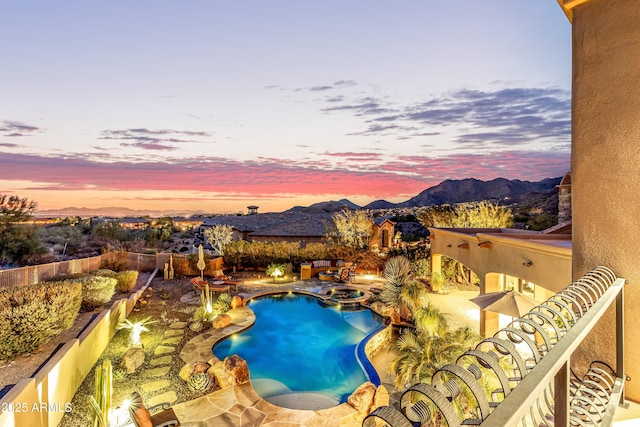 pool at dusk with an in ground hot tub and a mountain view