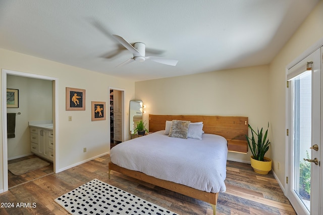 bedroom with ceiling fan, a walk in closet, dark wood-type flooring, and ensuite bath