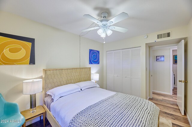 bedroom featuring ceiling fan, light hardwood / wood-style floors, and a closet