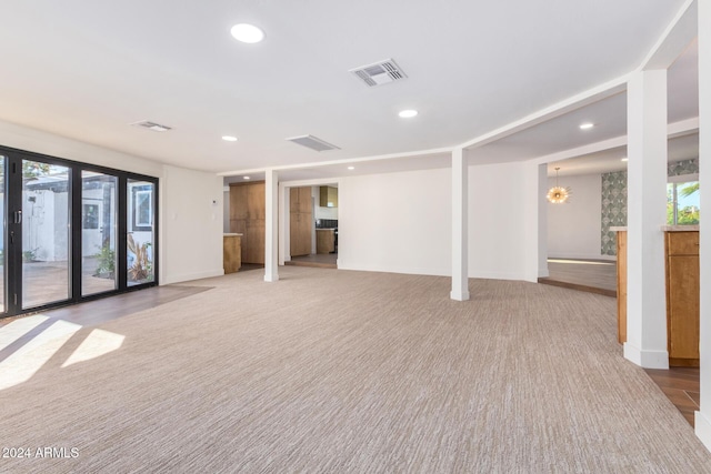 empty room featuring light colored carpet and an inviting chandelier