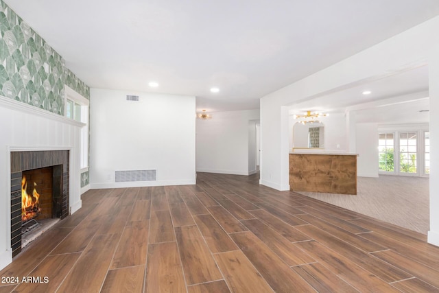 unfurnished living room with a fireplace and dark wood-type flooring