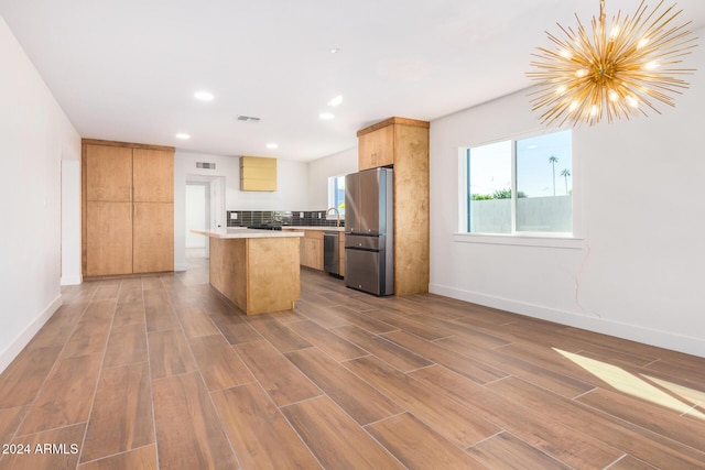 kitchen featuring a chandelier, a kitchen island, stainless steel appliances, and hardwood / wood-style flooring