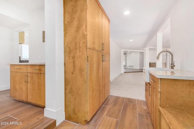 kitchen featuring light wood-type flooring and light stone counters