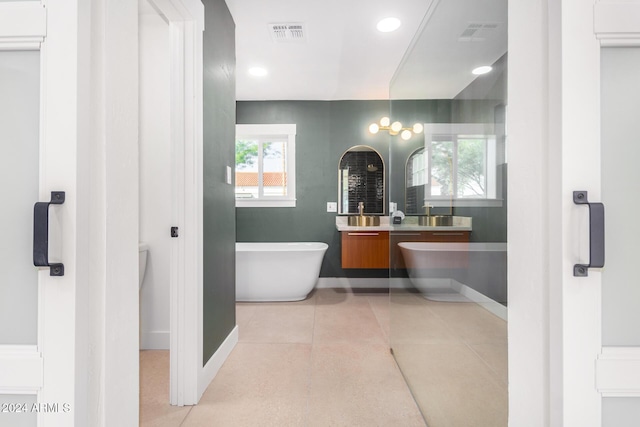 bathroom featuring a washtub, vanity, and tile patterned flooring