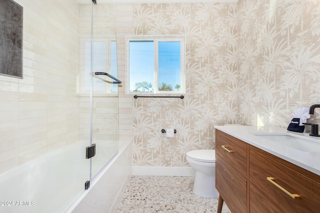 full bathroom featuring vanity, enclosed tub / shower combo, and toilet