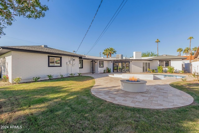 back of house with a patio, a yard, and a fire pit