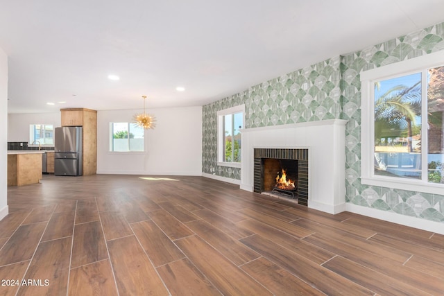 unfurnished living room with dark hardwood / wood-style flooring and sink