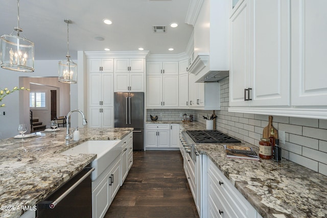 kitchen featuring appliances with stainless steel finishes, hanging light fixtures, and white cabinetry