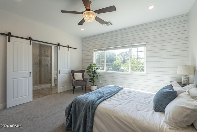 carpeted bedroom featuring ceiling fan and a barn door