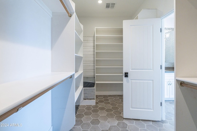 spacious closet with dark tile patterned floors