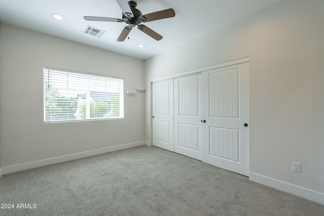 unfurnished bedroom with ceiling fan, light colored carpet, and a closet