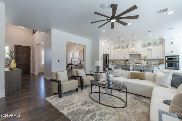 living room with ceiling fan, dark wood-type flooring, and sink