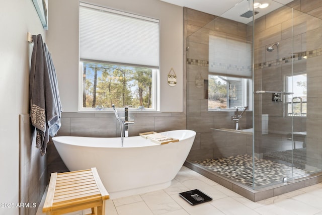 bathroom featuring tile walls and shower with separate bathtub