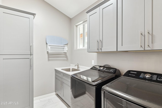 laundry area featuring cabinets, sink, and washer and dryer