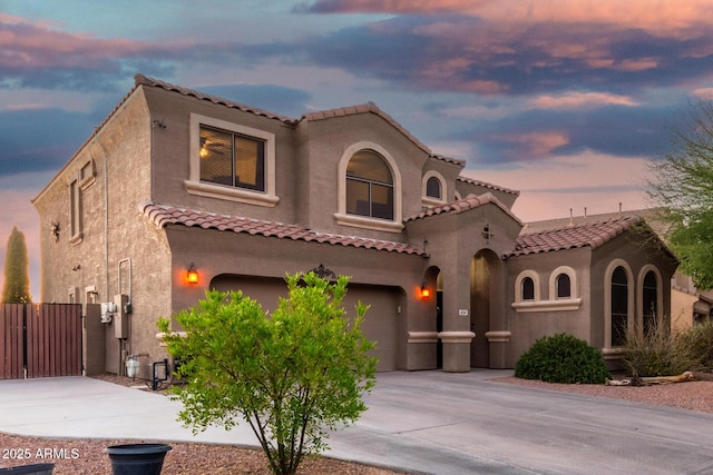 654 E Taylor Trl, San Tan Valley, AZ 85143 - mediterranean / spanish-style home featuring driveway, an attached garage, a tile roof, a gate, and stucco siding