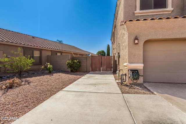 654 E Taylor Trl, San Tan Valley, AZ 85143 - view of side of property with stucco siding, concrete driveway, a gate, and a garage