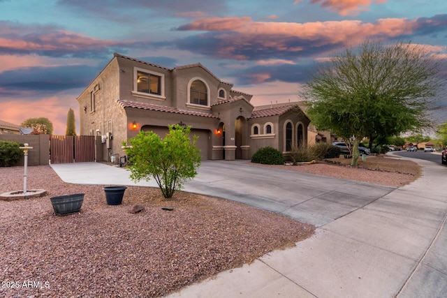 654 E Taylor Trl, San Tan Valley, AZ 85143 - mediterranean / spanish home featuring a gate, a garage, concrete driveway, stucco siding, and a tile roof