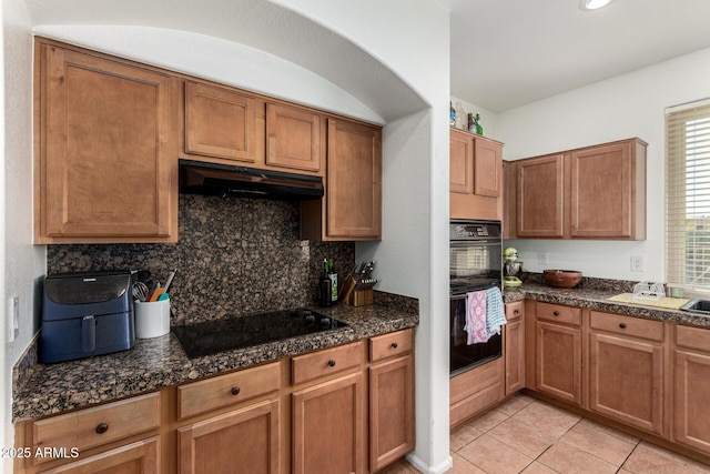 654 E Taylor Trl, San Tan Valley, AZ 85143 - kitchen with under cabinet range hood, black appliances, backsplash, light tile patterned flooring, and brown cabinets