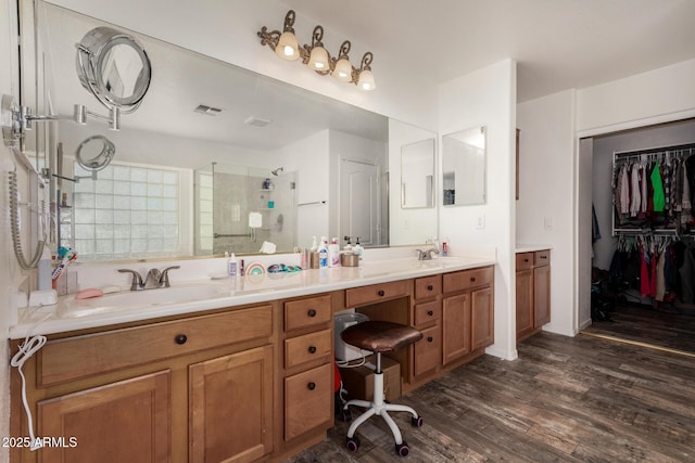 654 E Taylor Trl, San Tan Valley, AZ 85143 - full bathroom featuring double vanity, a shower stall, wood finished floors, and a spacious closet