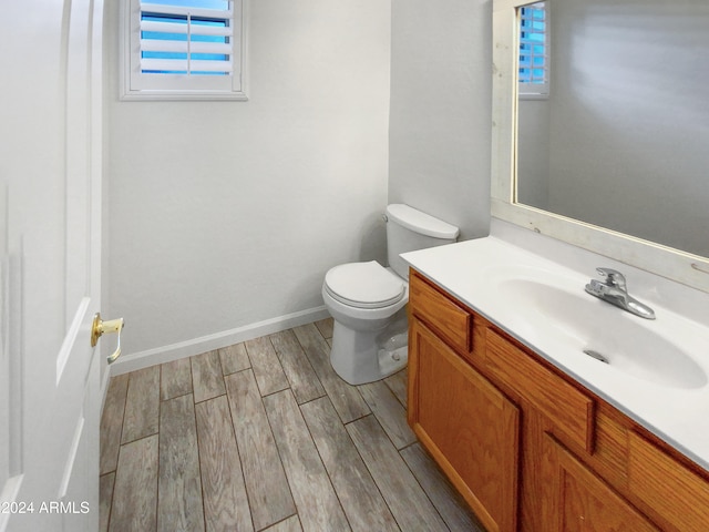 bathroom featuring hardwood / wood-style flooring, toilet, and vanity