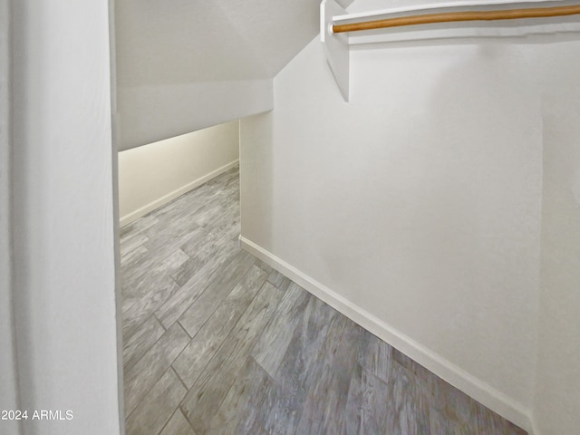 walk in closet featuring light wood-type flooring and vaulted ceiling