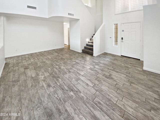 foyer featuring hardwood / wood-style flooring and a towering ceiling