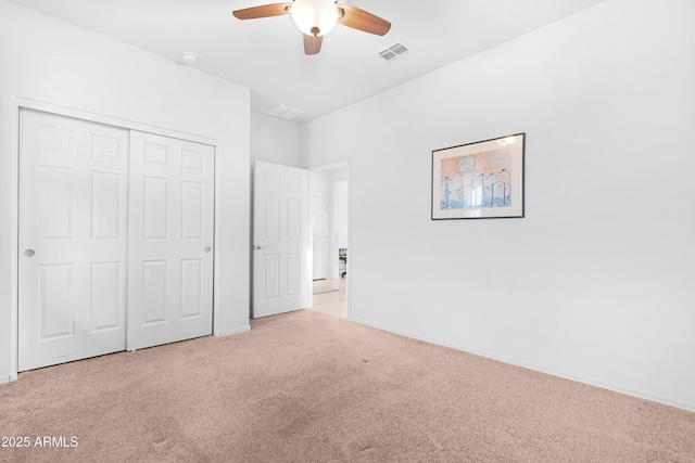 unfurnished bedroom featuring ceiling fan, light carpet, and a closet